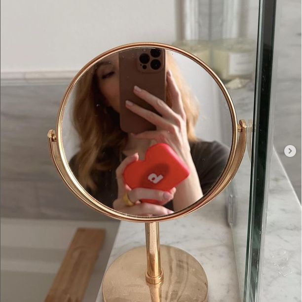 Mirror selfie holding dental aligners